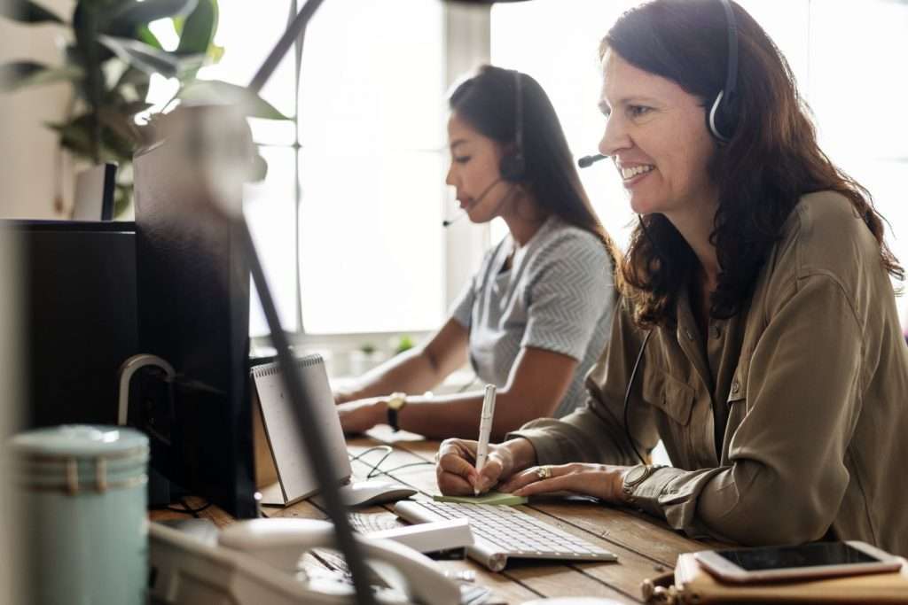 Customer service agents working with clients on phone